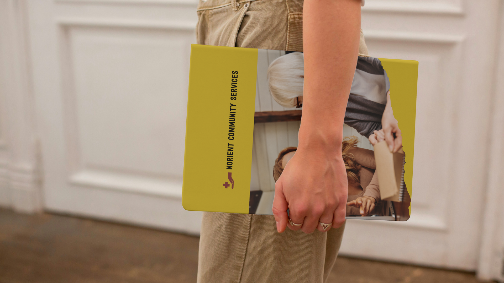 Image of a woman holding a Norient Community Services folder
